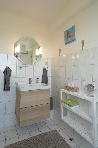 a bathroom with a sink and a mirror at Feriendomizil Strandblick Feriendomizil Strandblick Appartement 1 MeerBlick in Haffkrug