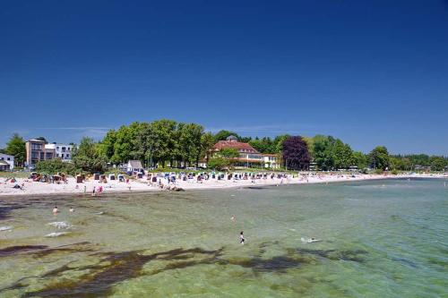 a beach with a lot of people in the water at Feriendomizil Strandblick Feriendomizil Strandblick Appartement 1 MeerBlick in Haffkrug