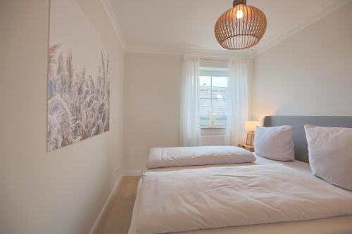 een witte slaapkamer met een bed en een raam bij Residenz Alte Bergstraße Residenz Alte Bergstrasse Appartement 17 in Scharbeutz