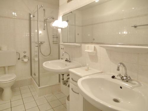 een badkamer met een wastafel, een toilet en een douche bij Haus Parkblick Parkblick Appartement 1 in Scharbeutz