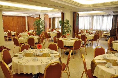 a banquet hall with tables and chairs with white tablecloths at Vergina Hotel in Thessaloniki