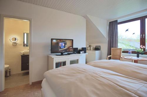 1 dormitorio con 1 cama y TV de pantalla plana en Appartemenhaus Linda-Lu Appartementhaus Linda-Lu Appartement 7, en Scharbeutz