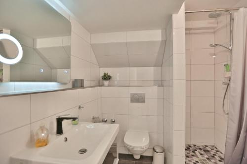 uma casa de banho branca com um lavatório e um WC em Residenz Ostseestrand Residenz Ostseestrand Appartement 32 em Scharbeutz