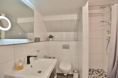 ein weißes Badezimmer mit Waschbecken und Toilette in der Unterkunft Residenz Ostseestrand Appartement 32 in Scharbeutz