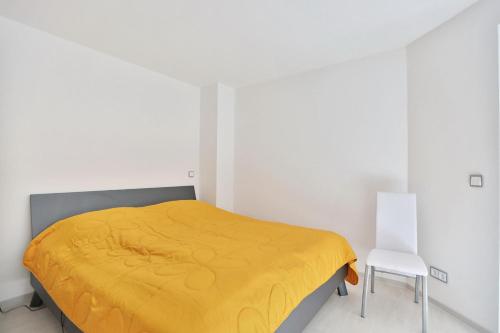 ein Schlafzimmer mit einem gelben Bett und einem Stuhl in der Unterkunft Residenz Ostseestrand Appartement 32 in Scharbeutz