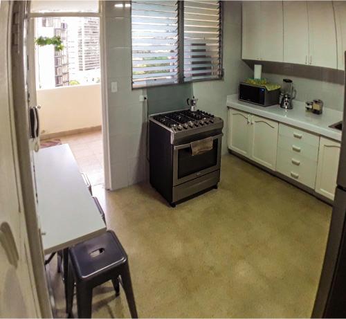 a kitchen with a stove top oven in a room at Habitaciones privadas en un departamento encantador in Panama City