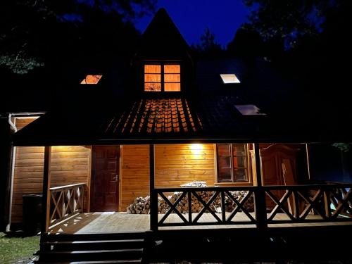 a wooden cabin with a porch at night at Marusia in Wajków