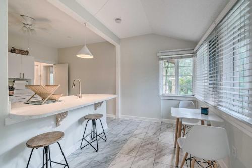 a kitchen with white walls and a counter and stools at Chic Ocala Home with Yard about 1 Mi to Dtwn Square in Ocala