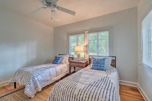 two beds in a room with a desk and windows at Chic Ocala Home with Yard about 1 Mi to Dtwn Square in Ocala