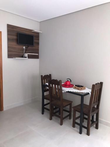 a dining room with a table and chairs and a tv at Quiosque 2 in Joanópolis