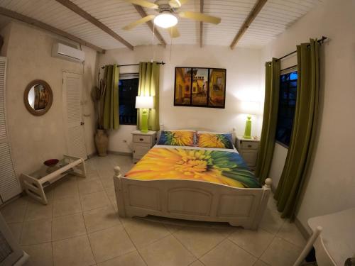 Un dormitorio con una cama y un ventilador de techo. en Yellow Bird Apartment, en Christ Church