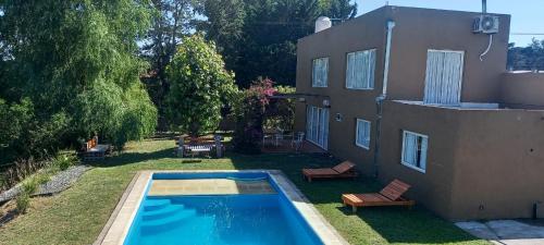 un patio trasero con piscina y una casa en Barrio colinas verdes Sierra De Los Padres Serranita Mar Del Plata en Sierra de los Padres