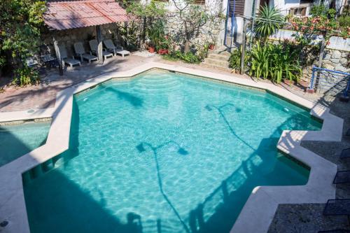 a large swimming pool with blue water at Hotel El Mirador in Puerto Escondido