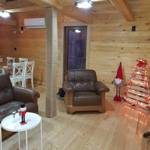 a living room with a couch and a christmas tree at Lozanski ambar in Boljevac