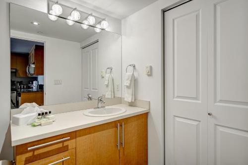 a bathroom with a sink and a mirror at Le Mille Neuf Apartments Modern Comfort in Downtown Montreal in Montréal