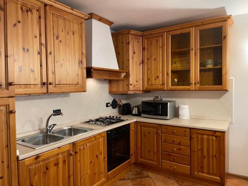 una cocina con armarios de madera y fregadero en Da Nonno Nani, en Venas