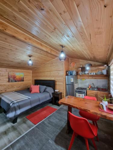 um quarto com uma cama e um tecto de madeira em Blue House Cabaña - Departamento - Habitación em Pucón