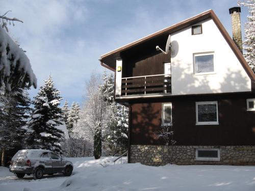a house with a car parked in the snow at Dušan in Štôla