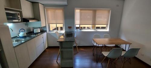 a small kitchen with a table and a table and chairs at Departamento con cochera muy bien ubicado en Ciudad Mendoza in Mendoza