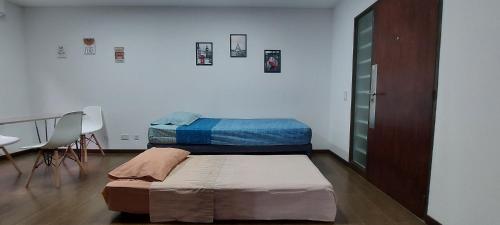 two beds in a room with a table and chairs at Departamento con cochera muy bien ubicado en Ciudad Mendoza in Mendoza