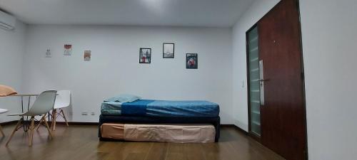 a bed in a room with a table and a chair at Departamento con cochera muy bien ubicado en Ciudad Mendoza in Mendoza