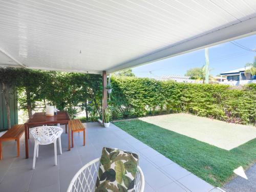 d'une terrasse avec une table et des chaises ainsi que d'un jardin. dans l'établissement Happy Dayz - Pet Friendly - Walk to Dog Beach, Restaurants & Playgrounds, à Gold Coast