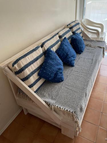 a couch with four blue pillows on it at Edificio Club del Mar in Punta del Este