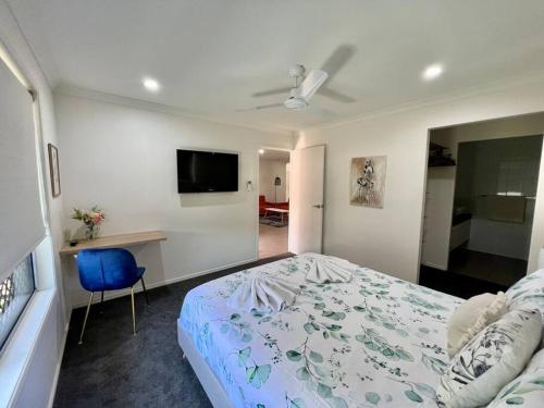 1 dormitorio con 1 cama y TV de pantalla plana en Lux in Bundy - Wifi, AC, Netflix and comfort, en Bundaberg