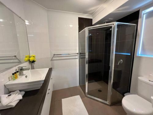 y baño con ducha, lavabo y aseo. en Lux in Bundy - Wifi, AC, Netflix and comfort, en Bundaberg