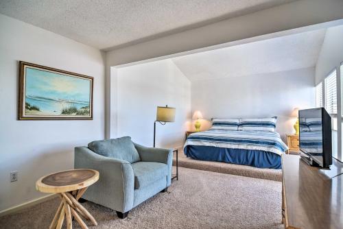 a bedroom with a bed and a chair and a television at Coastal Madeira Beach Condo - Walk to Gulf! in St. Pete Beach