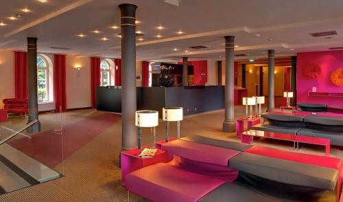 Cette chambre est dotée d'un mobilier et de colonnes roses et violets. dans l'établissement nestor Hotel Stuttgart-Ludwigsburg, à Ludwigsbourg
