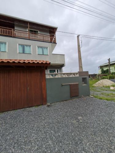 a house with a garage and a building at Siri Mariscal in Bombinhas