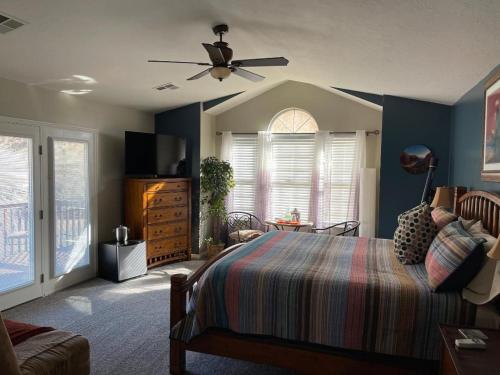 a bedroom with a bed and a ceiling fan at Harvest House Bed and Breakfast in Springdale