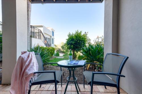 a patio with two chairs and a table on a porch at The Point Coolum in Coolum Beach