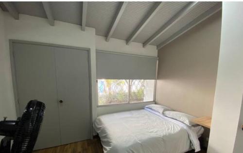 a bedroom with a bed and a window at Apartamento cerca al centro comercial Santafé A105 By Roots Rentals in Medellín