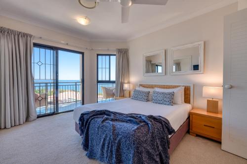 a bedroom with a bed and a large window at The Point Coolum in Coolum Beach