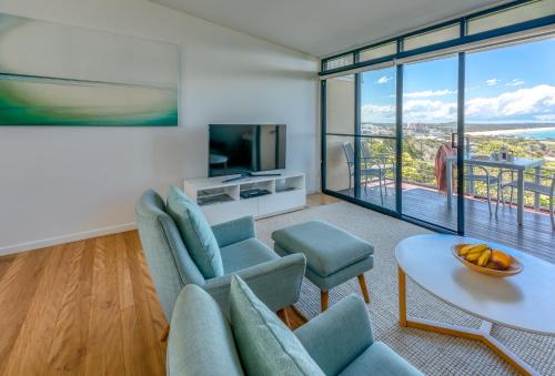 a living room with a couch and chairs and a table at The Point Coolum in Coolum Beach