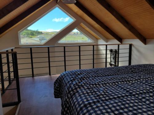 a bedroom with a bed and a large window at Cabañas Pidén in Punta Arenas