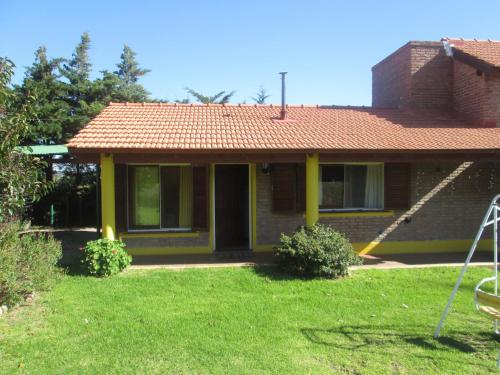 a house with a red roof and a yard at Pa-kuas del Uritorco in Capilla del Monte