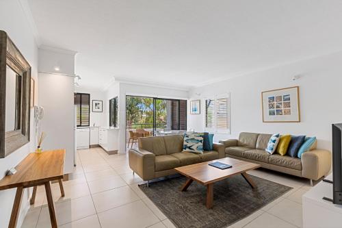 a living room with a couch and a table at Bella Casa Noosa in Noosa Heads