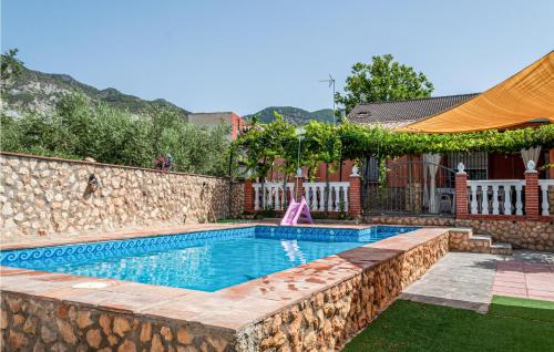 una piscina con un muro di pietra accanto a una casa di 2 Bedroom Lovely Home In Padul a Padul