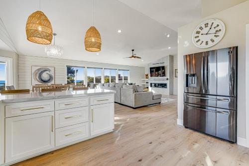 a kitchen with white cabinets and a clock on the wall at Sand Dollar Shore in Fort Bragg