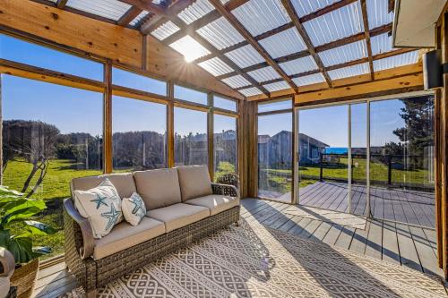 a living room with a couch in a room with windows at Sand Dollar Shore in Fort Bragg