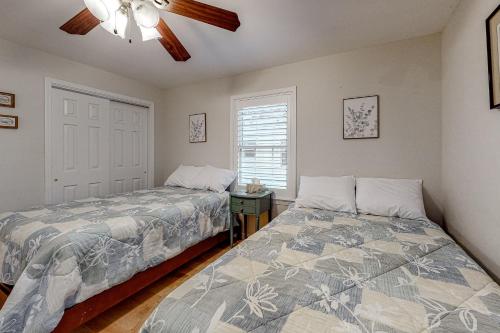 sypialnia z 2 łóżkami i wentylatorem sufitowym w obiekcie Whimsical Willow w mieście Ocean Pines