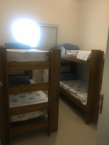zwei Etagenbetten in einem Zimmer mit Licht in der Unterkunft Apartamento Bertioga Torres in Bertioga