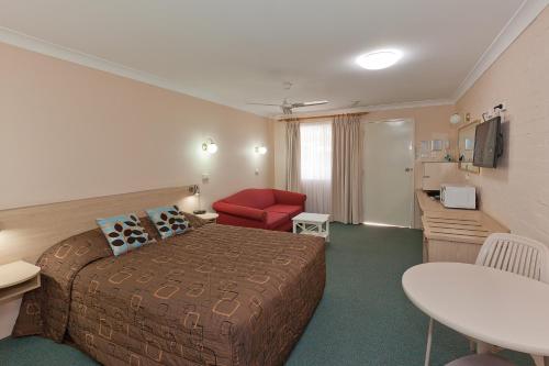 a hotel room with a bed and a table at Abraham Lincoln Motel in Tamworth