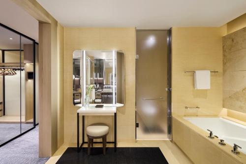 a bathroom with a tub and a sink and a bath tub at Four Seasons Hotel Hong Kong in Hong Kong