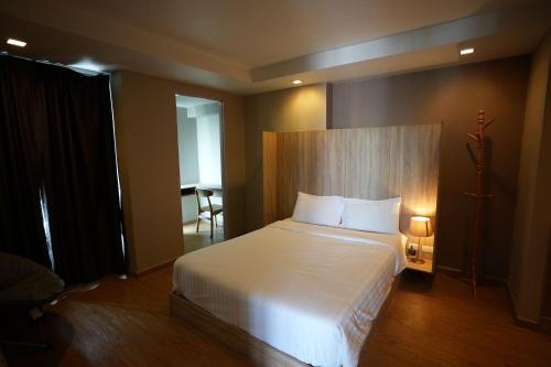 a bedroom with a large white bed in a room at Baan Tanwa - MRT Ratchadapisek in Bangkok