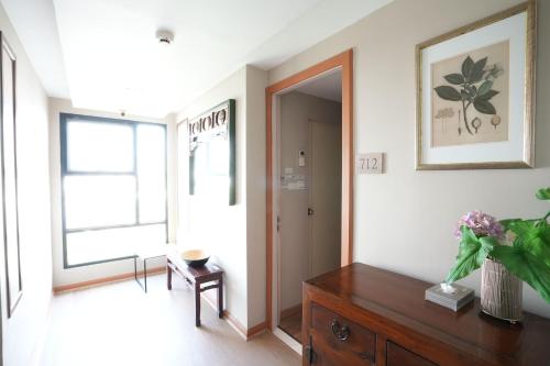 a living room with a wooden dresser and a window at Baan Tanwa - MRT Ratchadapisek in Bangkok