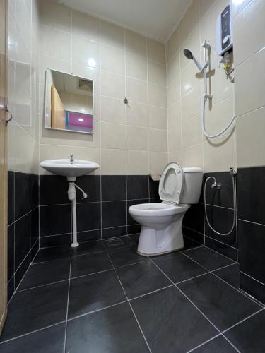 a bathroom with a toilet and a sink at Cassia Inn Kuching in Kuching
